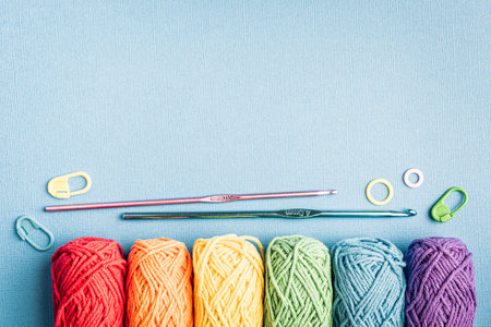 Crochet composition with cotton rainbow yarn, crochet hooks and accessories. Flat lay overhead shot with copy space, toned photoの写真素材