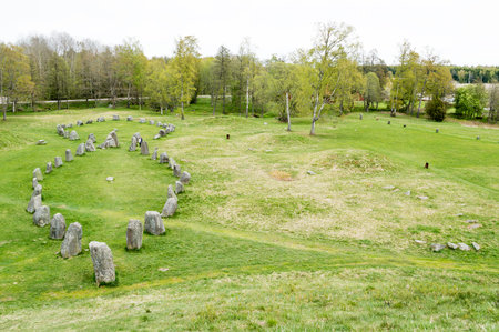 Large stone ship made of raised stones in Anundshog, Sweden. Also seen are burial mounds in the field.の写真素材
