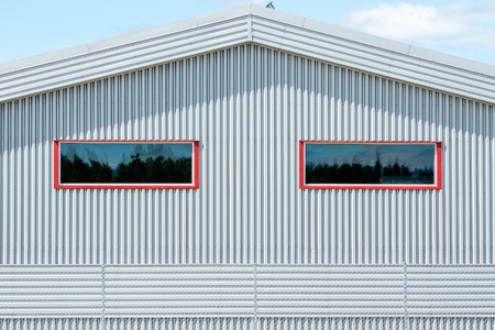 Grey metal fasade and red window frames.の写真素材
