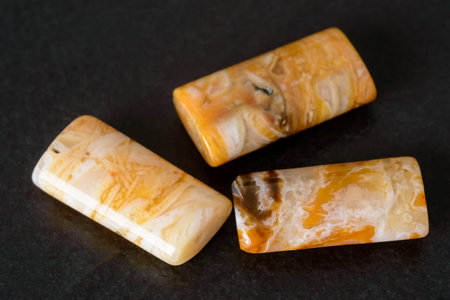 Lovely rectangle agate beads on black stone. Fine orange color and patterns.
