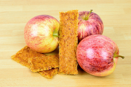 Natural fresh apples together with tasty dehydrated apple leather on wooden table. Dry fruit leather is a perfect bush tucker or bush food when on a hike.の写真素材
