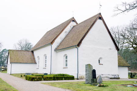 Hjortsberga church in Blekinge, Sweden. The oldest church in Blekinge.It was in use in the 12th century and has been renovated many times. Roof made of wooden chips. Overcast sky.のeditorial素材