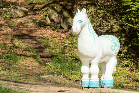 RONNEBY, SWEDEN - May 11, 2015: Life size white brook horse statue on a rock in the forest near a a small river. The brook horse is believed to be the soul of the river (water spirit).のeditorial素材