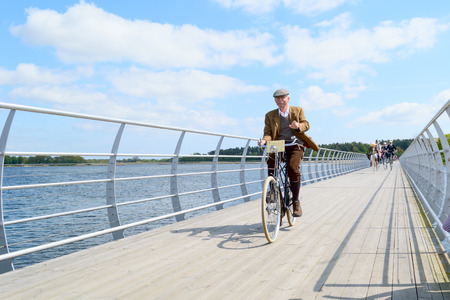 Solvesborg, Sweden - May 16, 2015: International Veteran Cycle Association (IVCA) 35th rally. Costume ride through public streets in town. Senior man on bridge.のeditorial素材