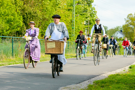 Solvesborg, Sweden - May 16, 2015: International Veteran Cycle Association (IVCA) 35th rally. Costume ride through public streets in town. Persons on old bikes.のeditorial素材
