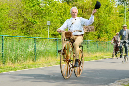 Solvesborg, Sweden - May 16, 2015: International Veteran Cycle Association (IVCA) 35th rally. Costume ride through public streets in town. Persons on old bikes.のeditorial素材