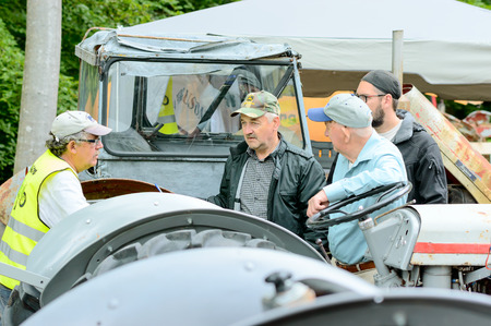 Bjorkeryd, Sweden - June 07, 2015: Small local event to show old industrial environment and local handicraft. Here are men talking about tractors.のeditorial素材