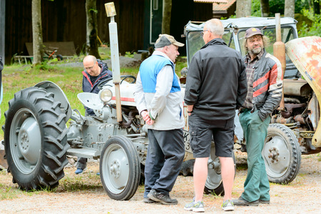 Bjorkeryd, Sweden - June 07, 2015: Small local event to show old industrial environment and local handicraft. Here are men talking about tractors.のeditorial素材