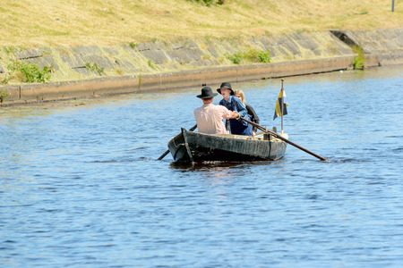Ronneby, Sweden - June 13, 2015: Sillarodden, a rowing contest from sea to town to sell herring. Young man screams and help rower to gain speed.のeditorial素材