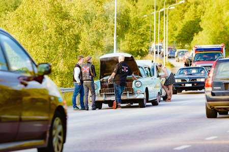 Ronneby, Sweden - June 26, 2015: Car break down and cause some chaos on the street during a road cruise for veteran cars. Drunk passengers behave unsafe and venture into street.のeditorial素材