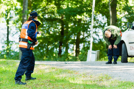Vaxjo, Sweden - September 09, 2015: Police education. Outdoor weapons and apprehension training in public area. Pretending criminal has just been sprayed by pepper spray and bend down hurting.のeditorial素材