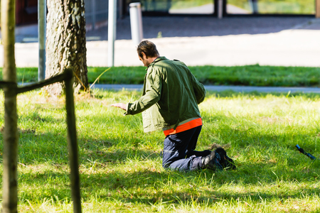 Vaxjo, Sweden - September 09, 2015: Police education. Outdoor weapons and apprehension training in public area. Male trainee pretending criminal on his knees in the grass.のeditorial素材