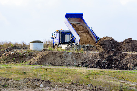 Kristianstad, Sweden - November 12, 2015: The old dump is slowly being transformed from a heap of garbage to a recreational area. Here a truck deposits some soil near a concrete gas outlet.のeditorial素材
