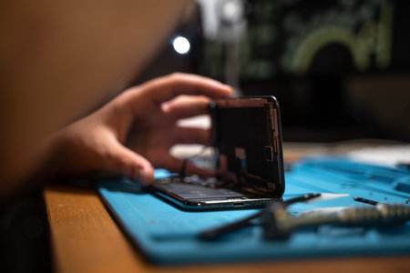 Hand technician open the smartphone to repair with a screwdriver