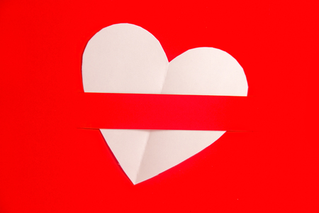 Heart shaped white paper in red background, Heart cut from white paper background, Valentines Day background, Holiday Card,の写真素材