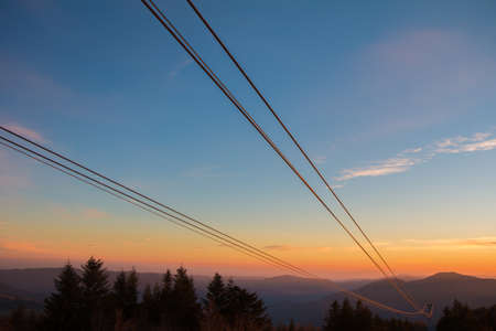 sunset through the cables of a cable car that go downstreamの写真素材
