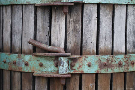 Old rusty lock on a wooden barrel. Rustic background. Close up.の写真素材