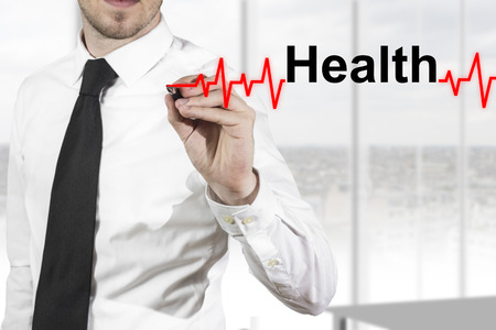 doctor in hospital drawing heartbeat line with healt in the airの写真素材