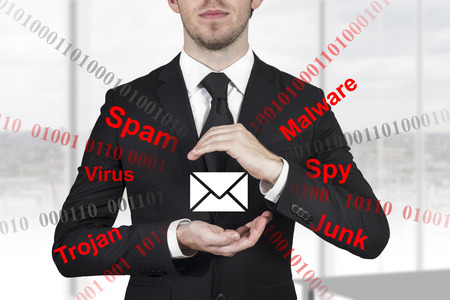 businessman in black suit protecting mail from spam attack malware with handsの写真素材