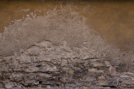 texture of rough half eroded sandstone wall dark yellowの写真素材