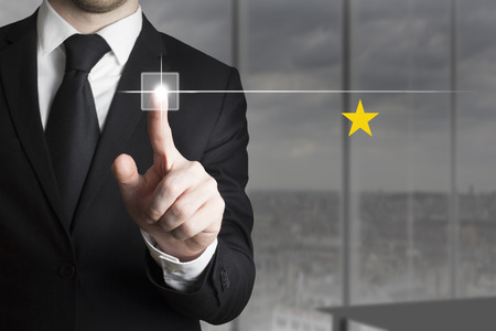 businessman in black suit pushing button one star ratingの写真素材