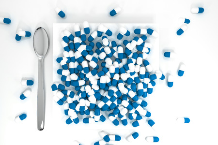 large pile of blue pills on white plate topviewの写真素材