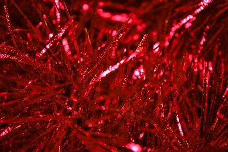 Close-up photo by beautiful red tinsel to background.の写真素材