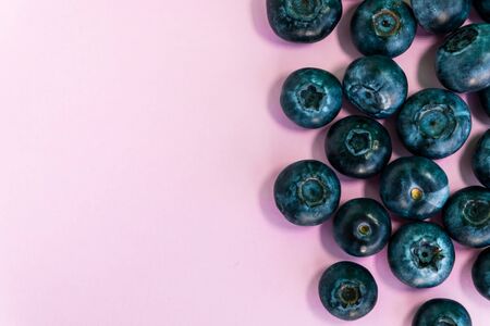 Blueberry on the pink background. Natural nutrition, sweet juicy berries. Pattern for the banner and wallpaper. Empty space for the text.の写真素材