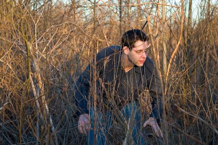 a guy creeping through the forestの写真素材