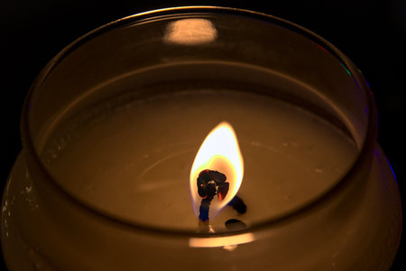 In the foreground the flame of a candle.の写真素材