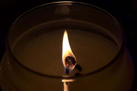 In the foreground the flame of a candle.の写真素材