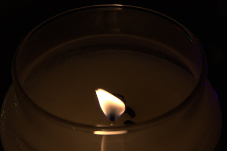 In the foreground the flame of a candle.の写真素材