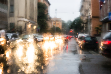 blurred light of cars seen through a wet windshield with some raindropsの写真素材
