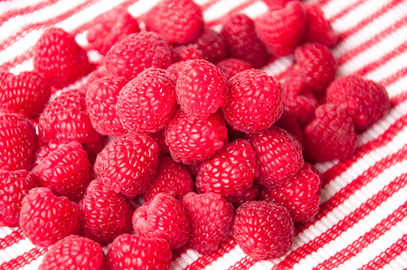 group of beautiful red raspberries on a striped background diagonalの写真素材