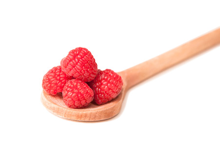 beautiful pink raspberries in a wooden spoon on a white backgroundの写真素材