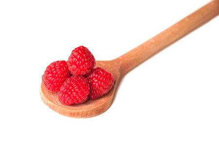 beautiful pink raspberries in a wooden spoon isolatedの写真素材