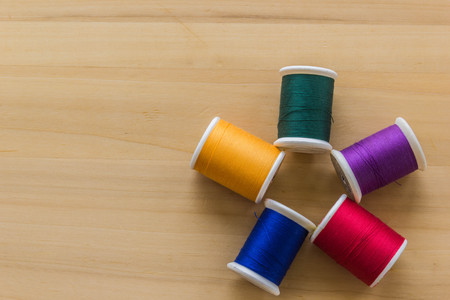 Colorful bobbin thread on wooden background, copy spaceの写真素材