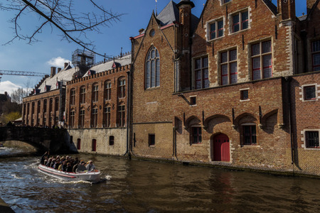 BRUGES, BELGIUM - MARCH 24 2018: City of Bruges with canal tour on March 24,2018 in Bruges, Belgiumのeditorial素材