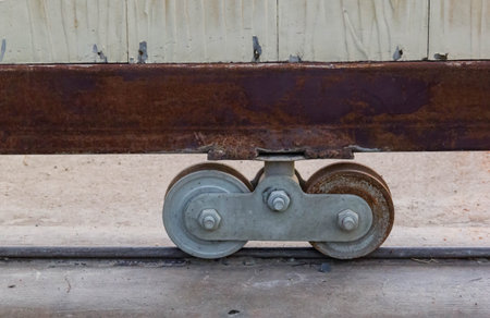 Rusty wheels of fence gate of the house with concrete floor