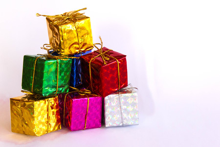Isolated pile of colorful gift boxes on white background, Christmas or New Year celebration conceptの写真素材