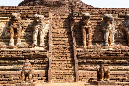 Decorated elephant sculptures around the ancient pagoda at Wat Chang Rob, Kamphaeng Phet Historical Park, Thailandの写真素材