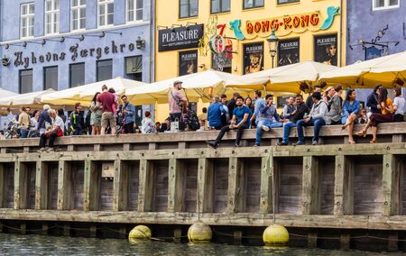 COPENHAGEN, DENMARK - JUNE 16 2018: People hanging out and sitting on embankment of Nyhavn canal on June 16,2018 in Copenhagen, Denmarkのeditorial素材