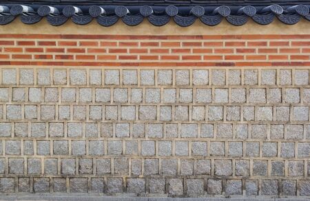 Background of ancient traditional Korean wall with tile roofの写真素材