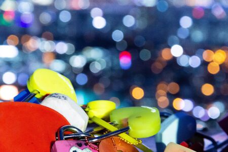 pile of heart-shaped padlock with bokeh blurred night backgroundの写真素材