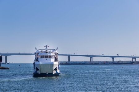 View of ferry cruise in the sea with background of bridge and waterfront pierの写真素材