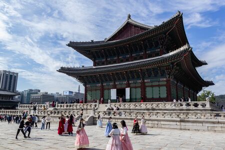 SEOUL, SOUTH KOREA - OCTOBER 18 2019: Tourists in hanbok dress, Korean traditional costume, at Geunjeongjeon hall in Gyeongbokgung palace on October 18, 2019 in Seoul, South Koreaのeditorial素材
