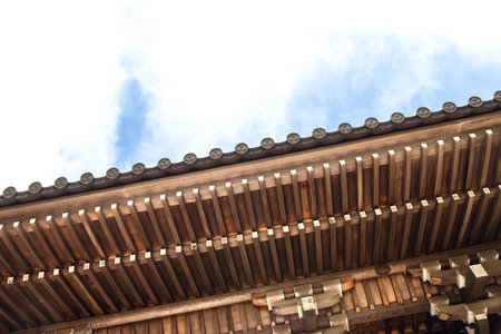 Facade of wooden traditional building in Japanese shrine with blue skyの写真素材