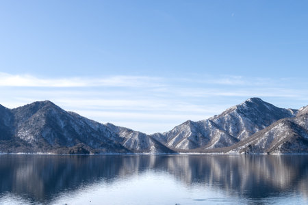 Landscape scenery of snow mountain at Lake Chuzenji in winter with reflection on water surfaceの写真素材