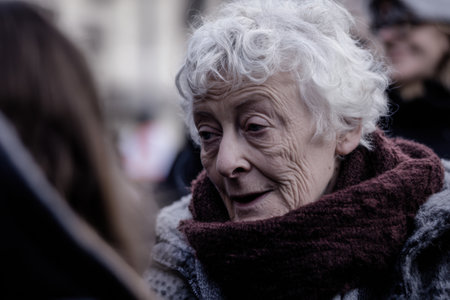 A candid street portrait of elderly woman with curly white hair, wearing scarf, expressing warmthの素材