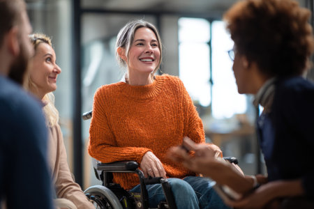 An empowered woman in wheelchair engaging with colleagues, showcasing inclusivity and teamworkの素材